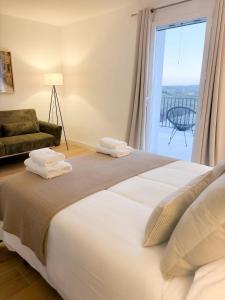 a bedroom with a large bed with a large window at Casa Puerta del Valle in Belalcázar