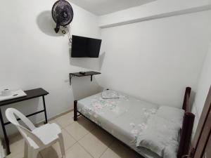 a bedroom with a bed and a chair and a desk at Guayacan Hostel in Cali