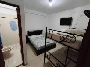 a bedroom with a bunk bed and a bathroom with a tub at Guayacan Hostel in Cali