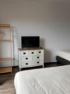 a white dresser with a television on top of it at La Casona Papudo in Papudo