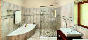 a bathroom with a tub and a sink and a shower at Serenity Cottages in Richmond +24 photos