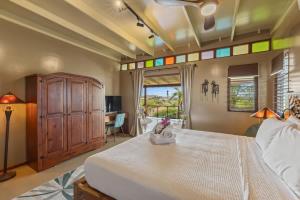 a bedroom with a bed and a desk and a window at Bali Suites - Penthouse in Willemstad