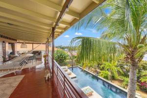 a balcony with a hammock and a palm tree at Bali Suites - Penthouse in Willemstad