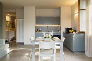 a kitchen and dining room with a white table and chairs at Orta Paradise 26 in Orta San Giulio +11 photos