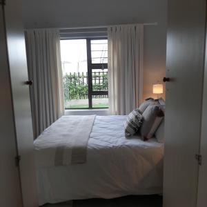 a bedroom with a bed and a large window at Caledonia Guest Room in Trichardt