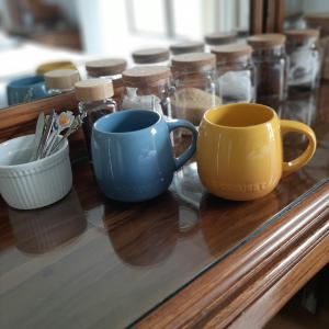 a table with two cups and jars on it at Caledonia Guest Room in Trichardt