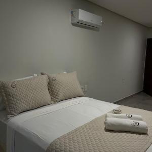 ein Bett mit zwei Kissen und einer Heizung an der Wand in der Unterkunft Murano Suits Hotel in João Pessoa + 54 Fotos