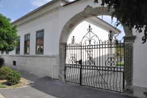 an entrance to a white building with an iron gate at R40 Vendégház in Mád