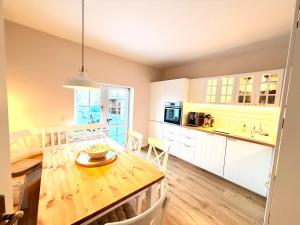 a kitchen and dining room with a wooden table at Boddenhuus - Traumhaus mit Steg und Boot in Zudar