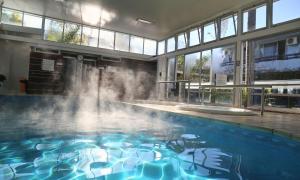 a swimming pool with a fountain in a building at Aguasol Hotel Termal in Termas del Daymán