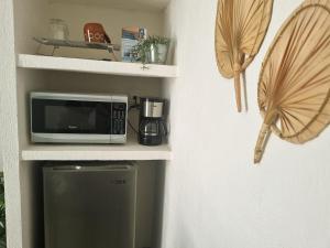 a microwave sitting on a shelf next to a refrigerator at La casa del mar in Manzanillo