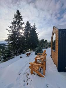 a picnic table in the snow next to a cabin at Natura Tiny House in Mărişel +6 photos