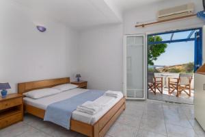 a bedroom with a bed and a balcony with a view at Tina's Apartments in Adamantas