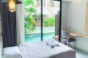 a bedroom with a bed and a view of a pool at Gemini Star Hotel Kuta in Kuta +111 photos