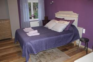 - une chambre violette avec un lit et des serviettes dans l'établissement Au Relais Du Canal à Grand Gabarit, à Nesle