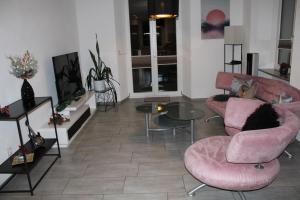 a living room with pink chairs and a table at Business Apartment Turgi in Turgi +17 photos