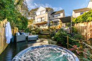 a backyard with a jacuzzi tub in front of a house at 4 Bed in Carbis Bay oc-m30075 in Carbis Bay