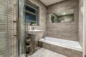 a bathroom with a tub and a sink and a mirror at 4 Bed in Carbis Bay oc-m30075 in Carbis Bay +33 photos