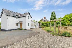 an exterior view of a white house with a driveway at 2 Bed in Yatton oc-s32603 in Leinthall Earls