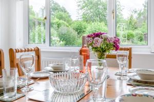 a dining room table with a bottle of wine and flowers at 2 Bed in Yatton oc-s32603 in Leinthall Earls