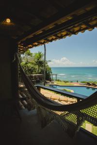a hammock in a room with a view of the ocean at Beijo do Vento Pousada in Arraial d'Ajuda