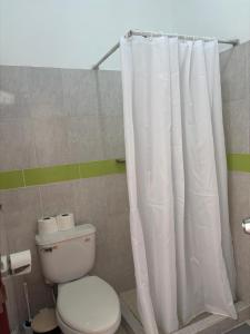 a bathroom with a toilet and a shower curtain at Casa Bonita by Mireya in Bayahibe +12 photos