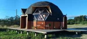 a large dome house with a wooden deck at Domo loft puacura - tinaja disponible in Castro