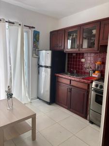 a kitchen with wooden cabinets and a refrigerator at Casa Bonita by Mireya in Bayahibe