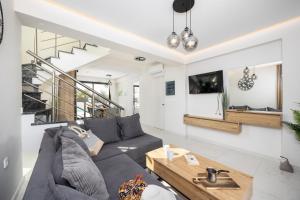 a living room with a couch and a table at Villa Infinity Ena in Kalamaki