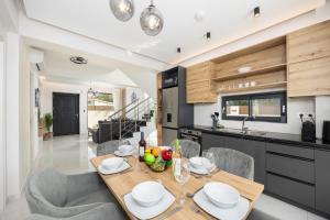 a kitchen and dining room with a table and chairs at Villa Infinity Ena in Kalamaki