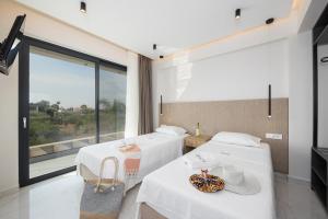 two beds in a room with a large window at Villa Infinity Ena in Kalamaki +20 photos