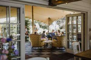 a group of people sitting in chairs on a patio at B&B Hullebrug in Heist-op-den-Berg