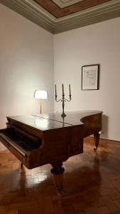 a piano in a room with a lamp and candles at Studio Balcescu in Sibiu
