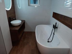 a white bathroom with a tub and a sink at Pension Aneta in Vysoké nad Jizerou +20 photos