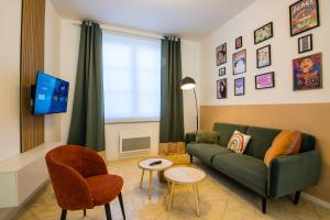 a living room with a green couch and a tv at Hesdin Appart Holidays 1 in Hesdin