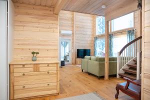 a room with a staircase and a living room with wooden walls at Villa Siltasaari in Sotkamo