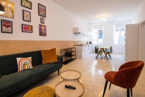 a living room with a green couch and a table at Hesdin Appart Holidays 1 in Hesdin