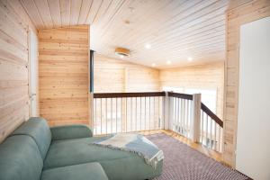 a living room with a blue couch in a room with wooden walls at Villa Siltasaari in Sotkamo