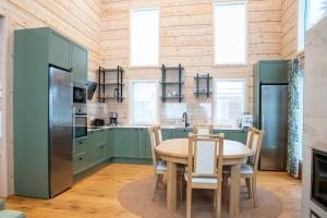 a kitchen with green cabinets and a table with chairs at Villa Siltasaari in Sotkamo
