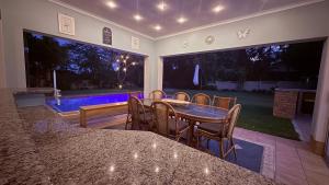 a dining room with a table and chairs and a pool at Umhlanga La Lucia Oasis, Family Friendly Accommodation in Durban