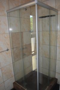 a shower with a glass door in a bathroom at Casa Tapyí Paso in Paso de la Patria