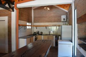a kitchen with a wooden table and a refrigerator at Casa Tapyí Paso in Paso de la Patria