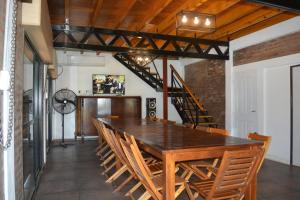 a dining room with a wooden table and chairs at Casa Tapyí Paso in Paso de la Patria