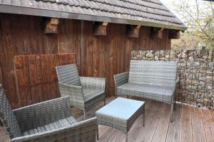 a group of chairs and a table on a deck at Ferienwohnung Storchennest in Bad Liebenstein