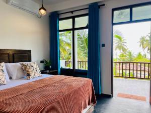a bedroom with a bed and a large window at ANB Surf View in Tangalle