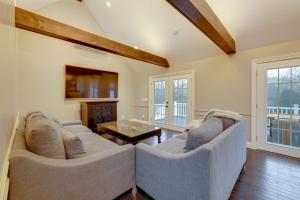 a living room with two couches and a table at Summer Beach Pass: Wooded Martha's Vineyard Escape in Vineyard Haven