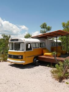 a yellow and white bus parked with a tent on it at Refúgio Veadeiros Ônibus in Sao Jorge