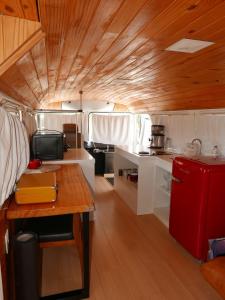 a kitchen with a table and a red refrigerator at Refúgio Veadeiros Ônibus in Sao Jorge +21 photos