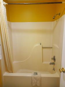 a bathroom with a tub and a shower and a sink at LACENTER MOTEL in La Center