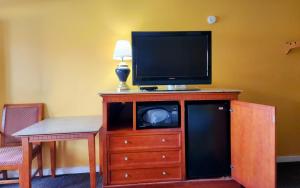 a television on top of a wooden dresser at LACENTER MOTEL in La Center